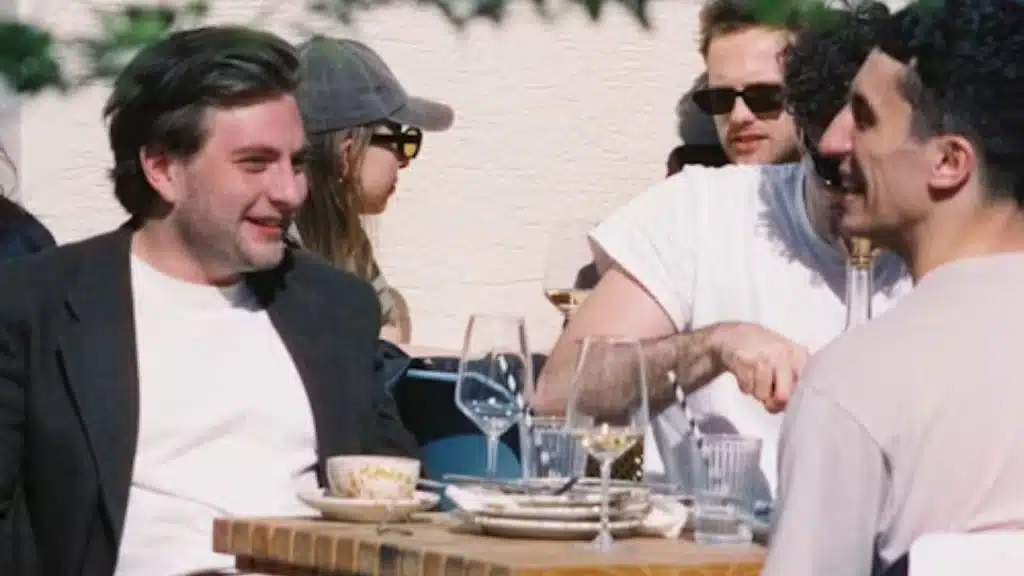 Man smiling confidently while talking with friends
