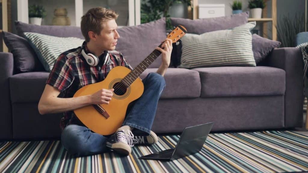 Man enjoying guitar practice at home