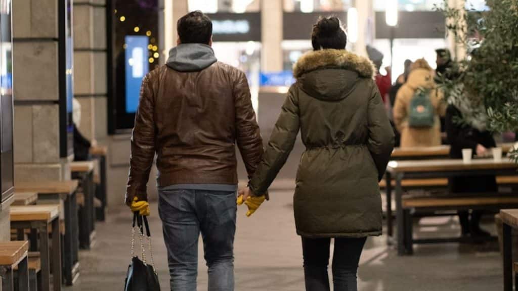 Couple holding hands while walking outside