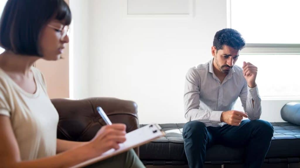 Man in therapy session with supportive counselor