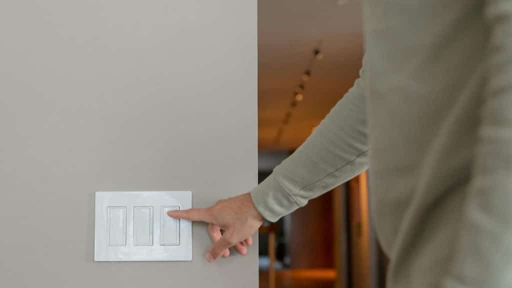 A person turning off a light switch on a wall.