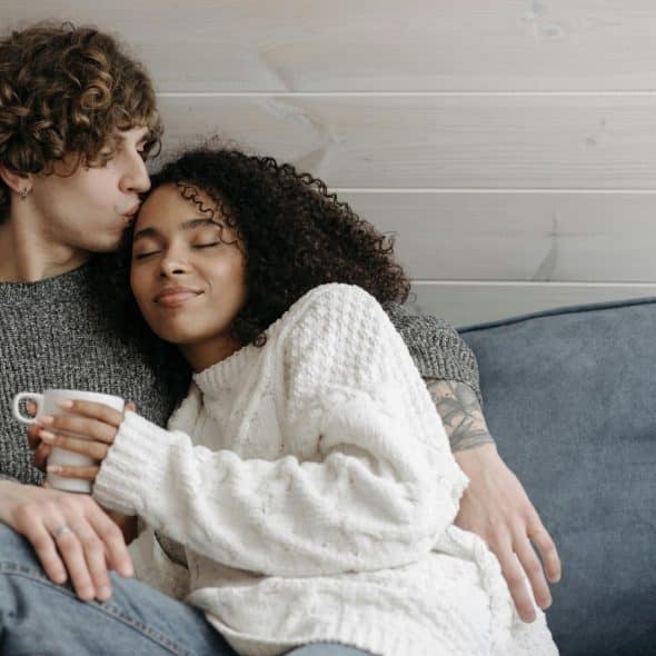 A man kissing a woman’s forehead