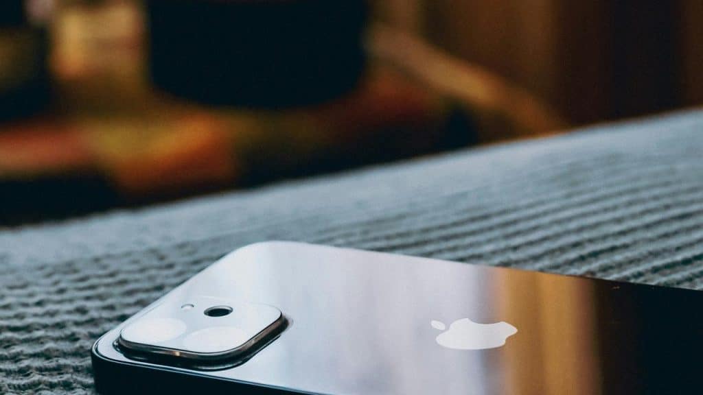 An iPhone resting on a textured surface.