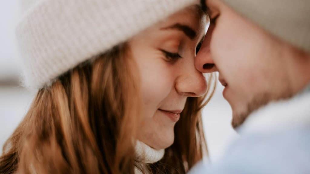 A close-up of a couple touching foreheads and smiling softly.