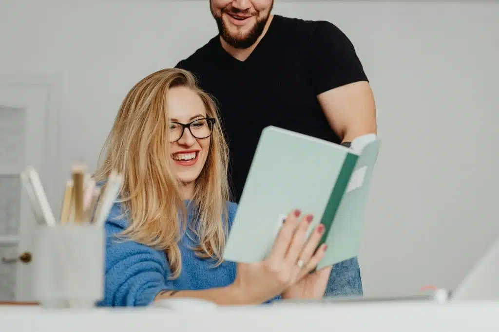 A man and woman looking at the notebook