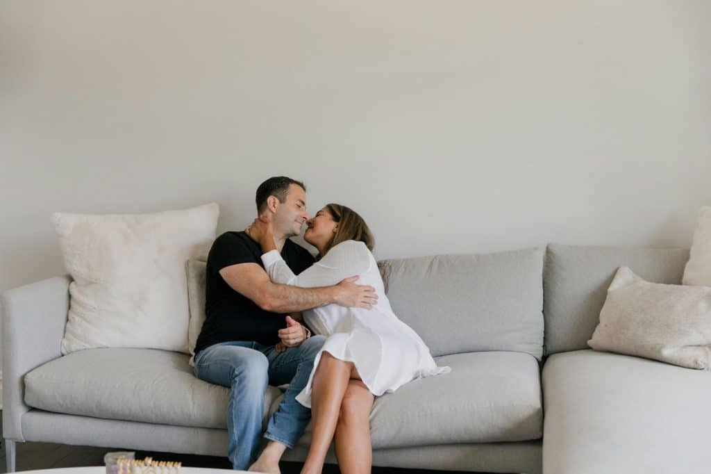 A man and woman cuddling at the sofa