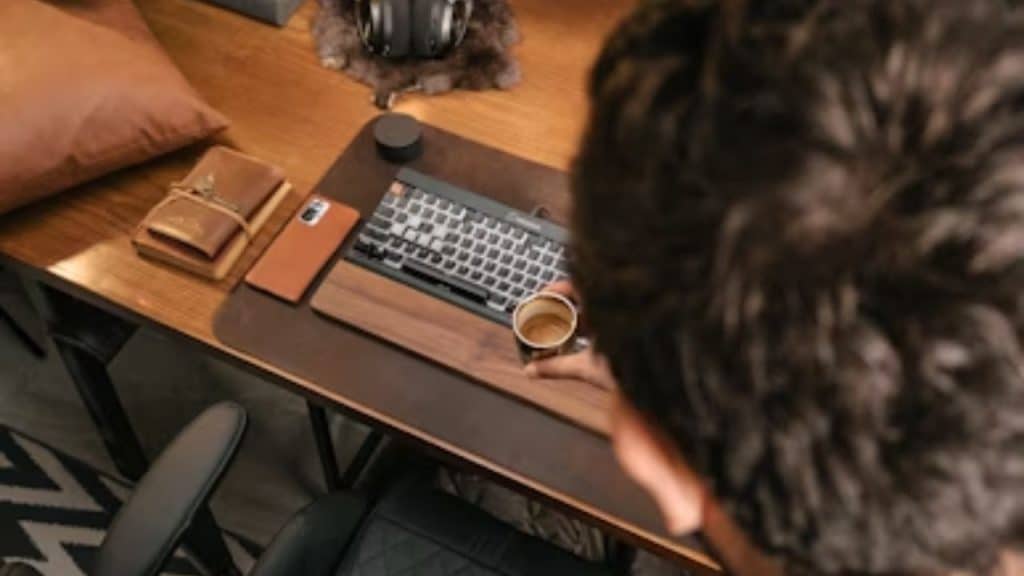 A man putting his phone on a desk and walking away