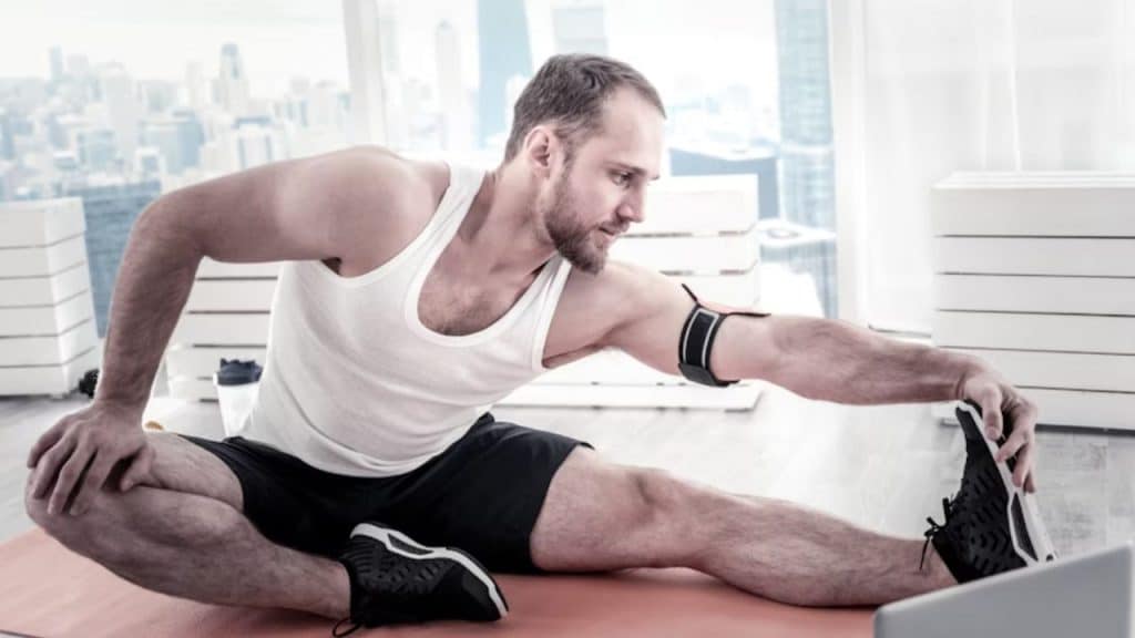 A man stretching on a yoga mat at home