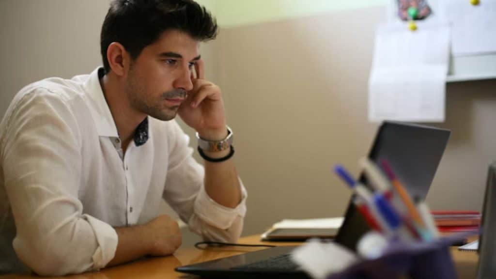 A man reviewing financial documents on his laptop