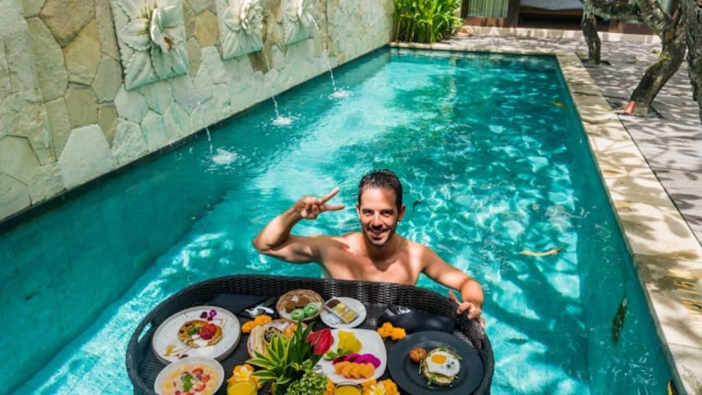 A man with a balanced holiday plate with vegetables, lean protein and fruits on a tray in a pool
