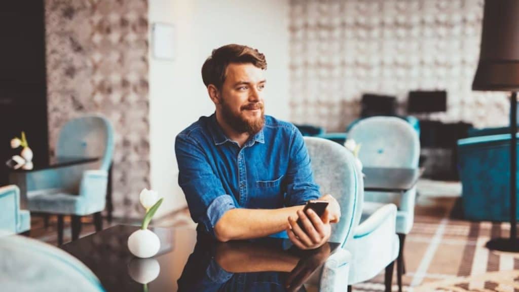 Man smiling while waiting calmly at a restaurant table