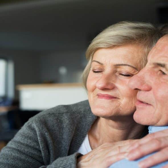 A mature couple cuddling at home