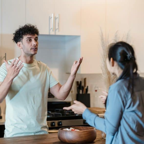 A man and woman arguing at the kitchen