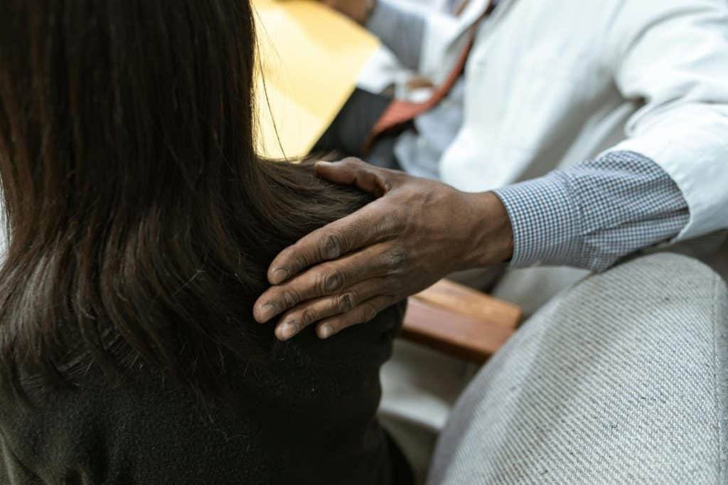 A man patting a woman’s shoulder