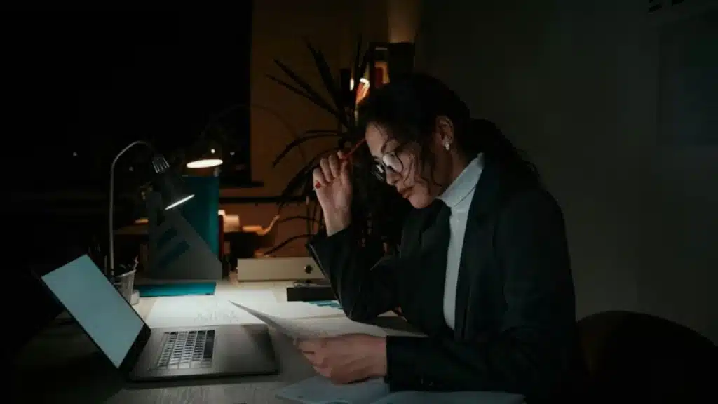 A wife working on a laptop in another room to avoid being with her husband