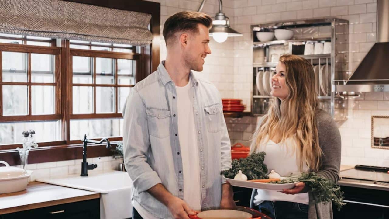 A man and a woman cooking dinner together in a cozy kitchen.