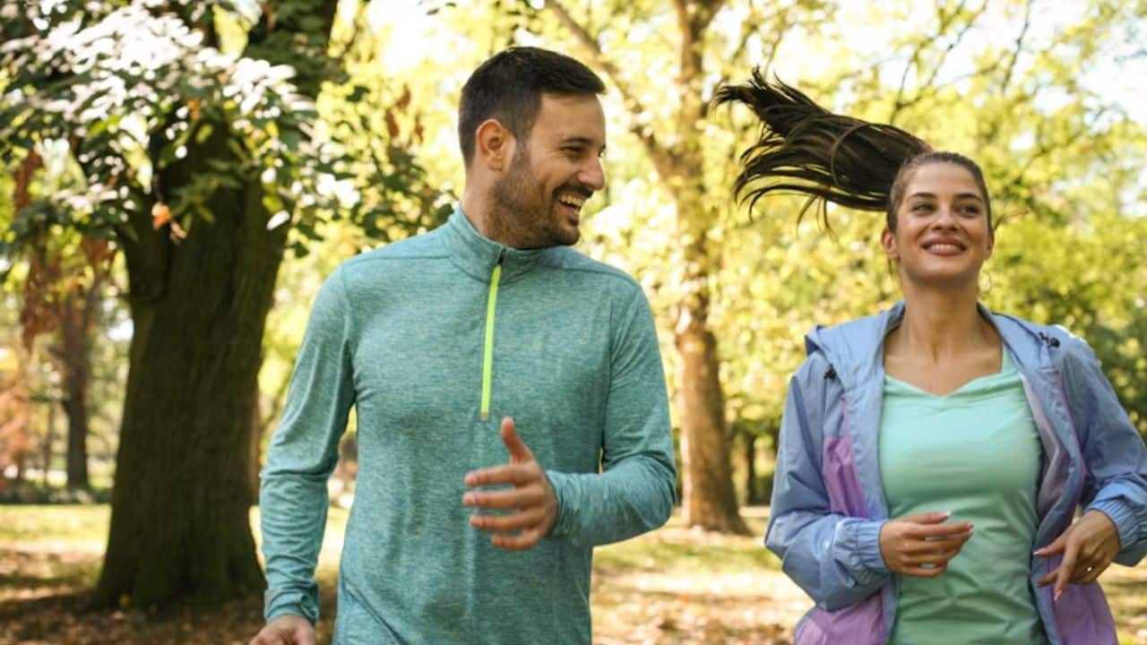 Couple jogging together in a park.