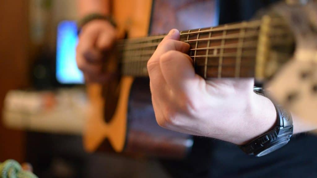 A person plays an acoustic guitar close-up.