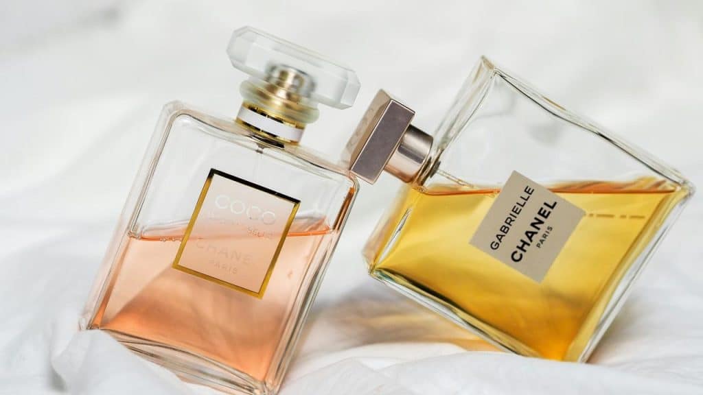 A pair of Chanel perfume bottles lying on a white surface.