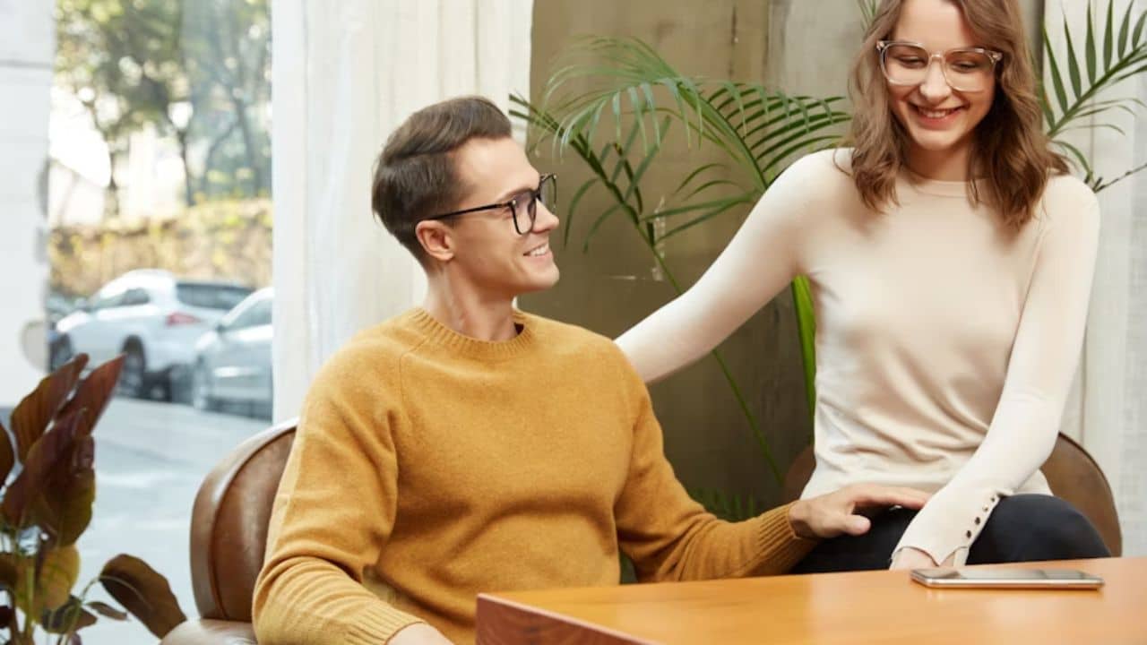 Couple sitting on a couch, man listening attentively while woman talks.