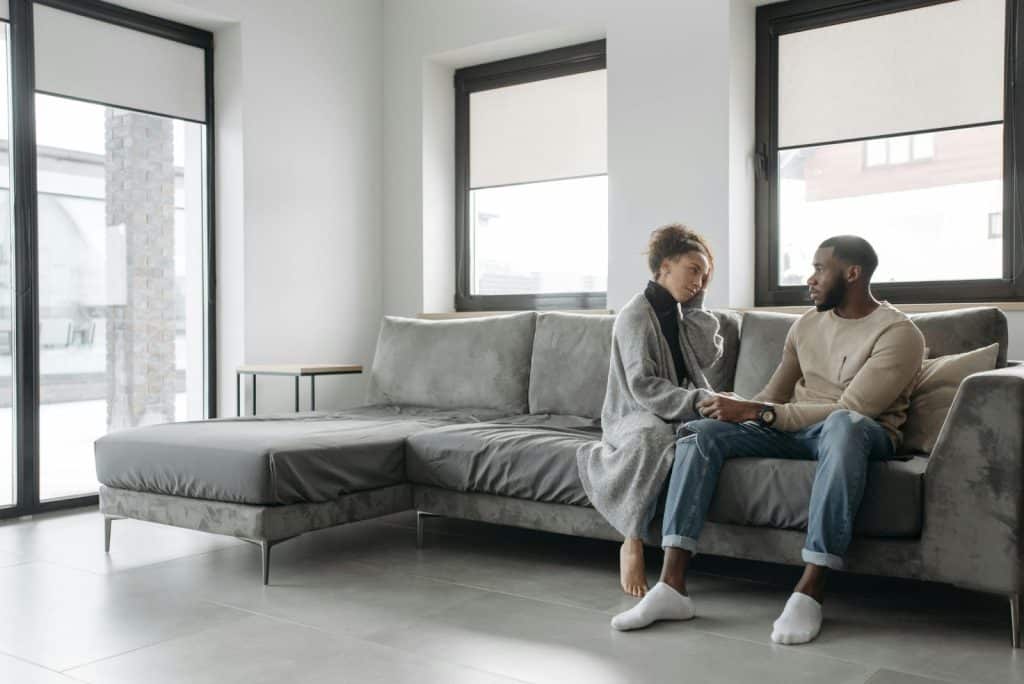 A man and woman at the couch talking
