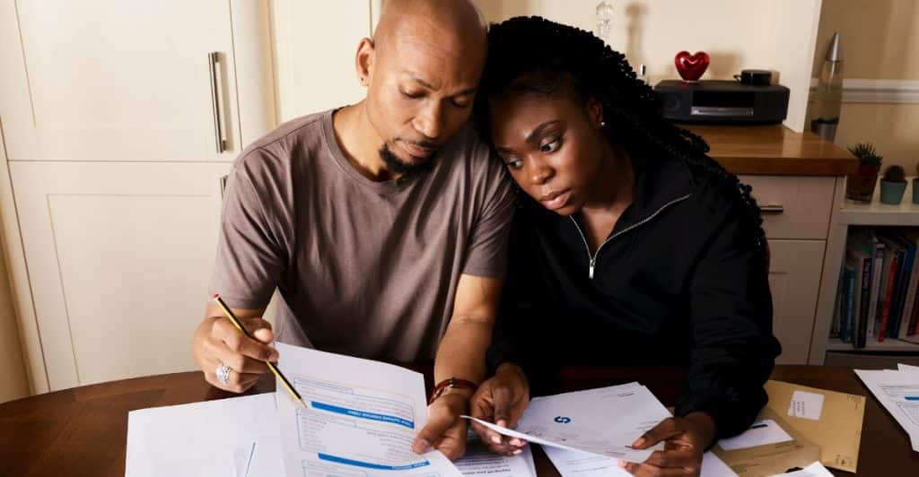 A man and woman checking their bills