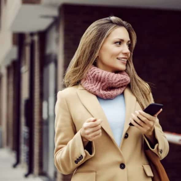 A confident woman walking alone through a city street, looking empowered