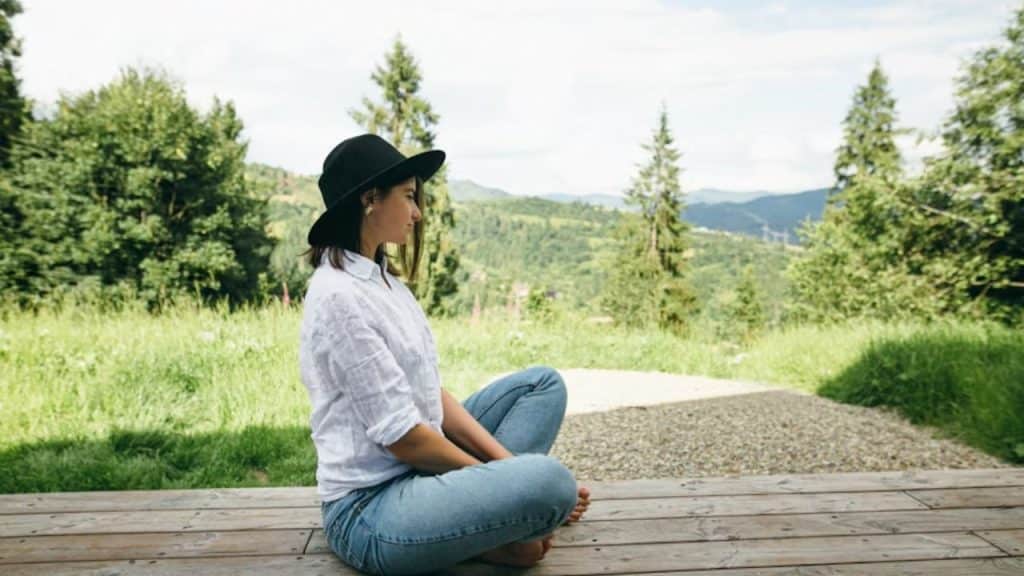 Woman meditating outdoors in a peaceful setting