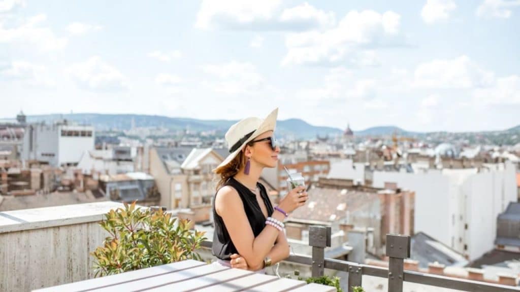 Woman sitting confidently on a balcony overlooking the city