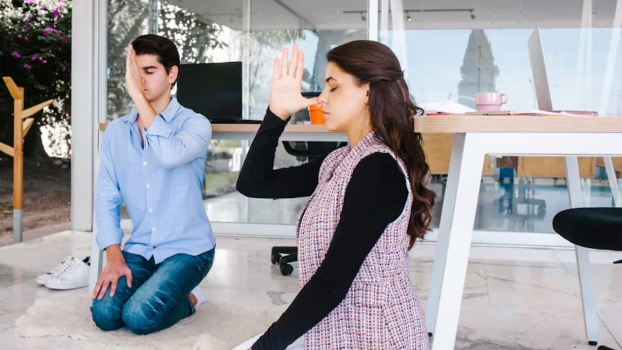 Couple meditating together in a bright living room.