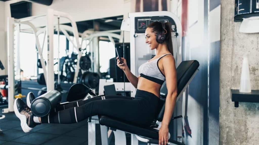 Woman using a wellness app on her smartphone while at the gym