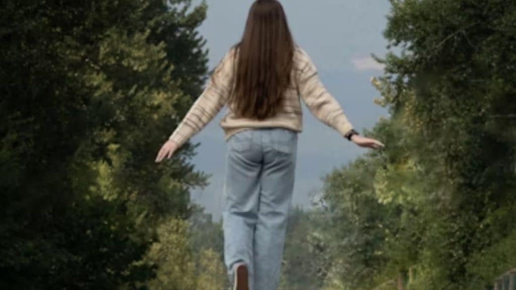 Woman walking confidently down a road alone with determination