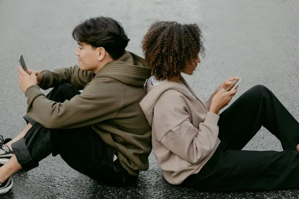 A man and woman sitting and using phone