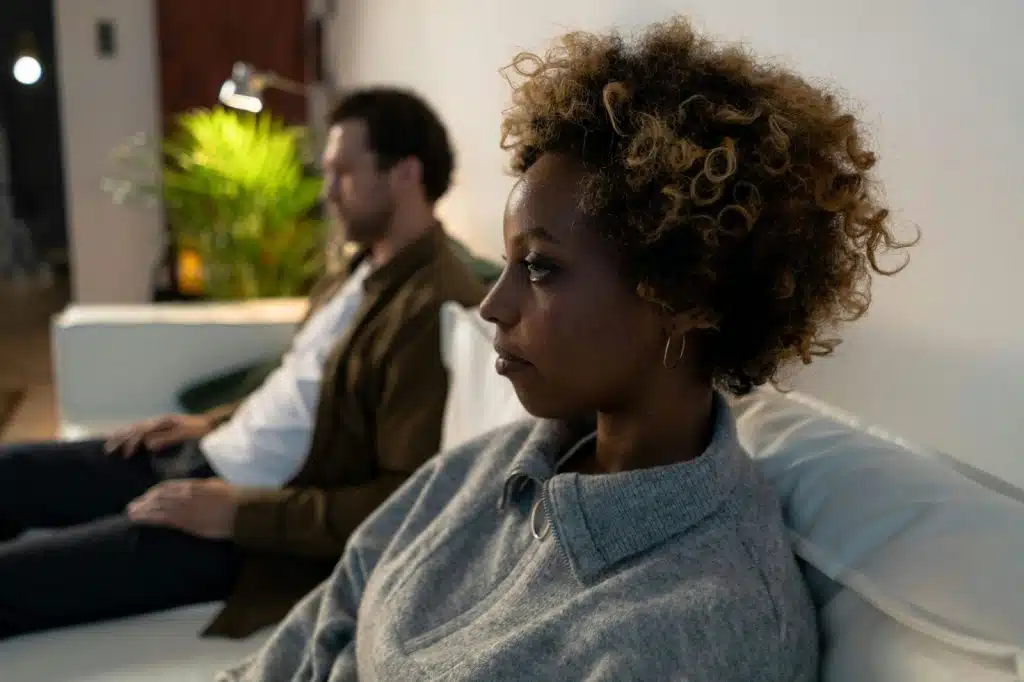 A man and woman sitting away from each other