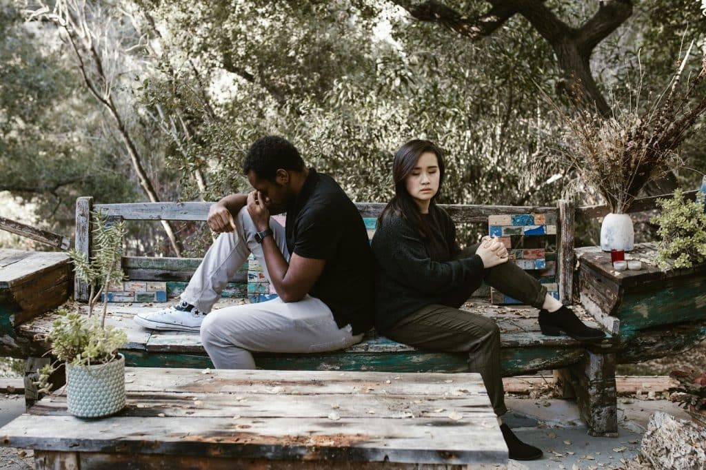 A man and woman sitting at the bench