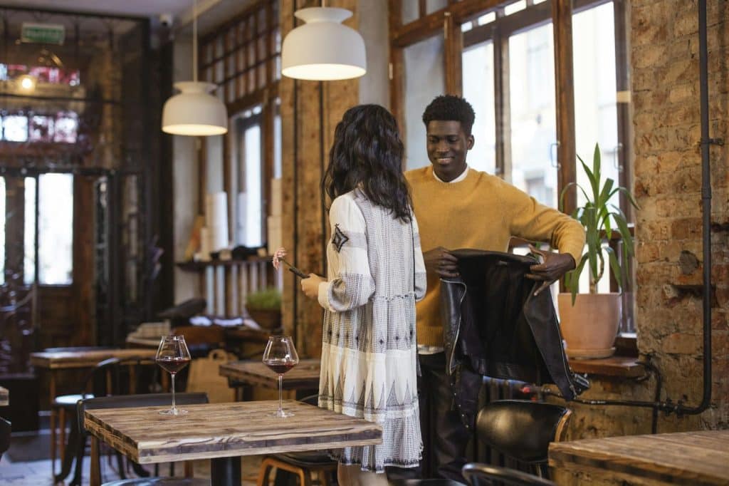 A man offering a jacket to woman