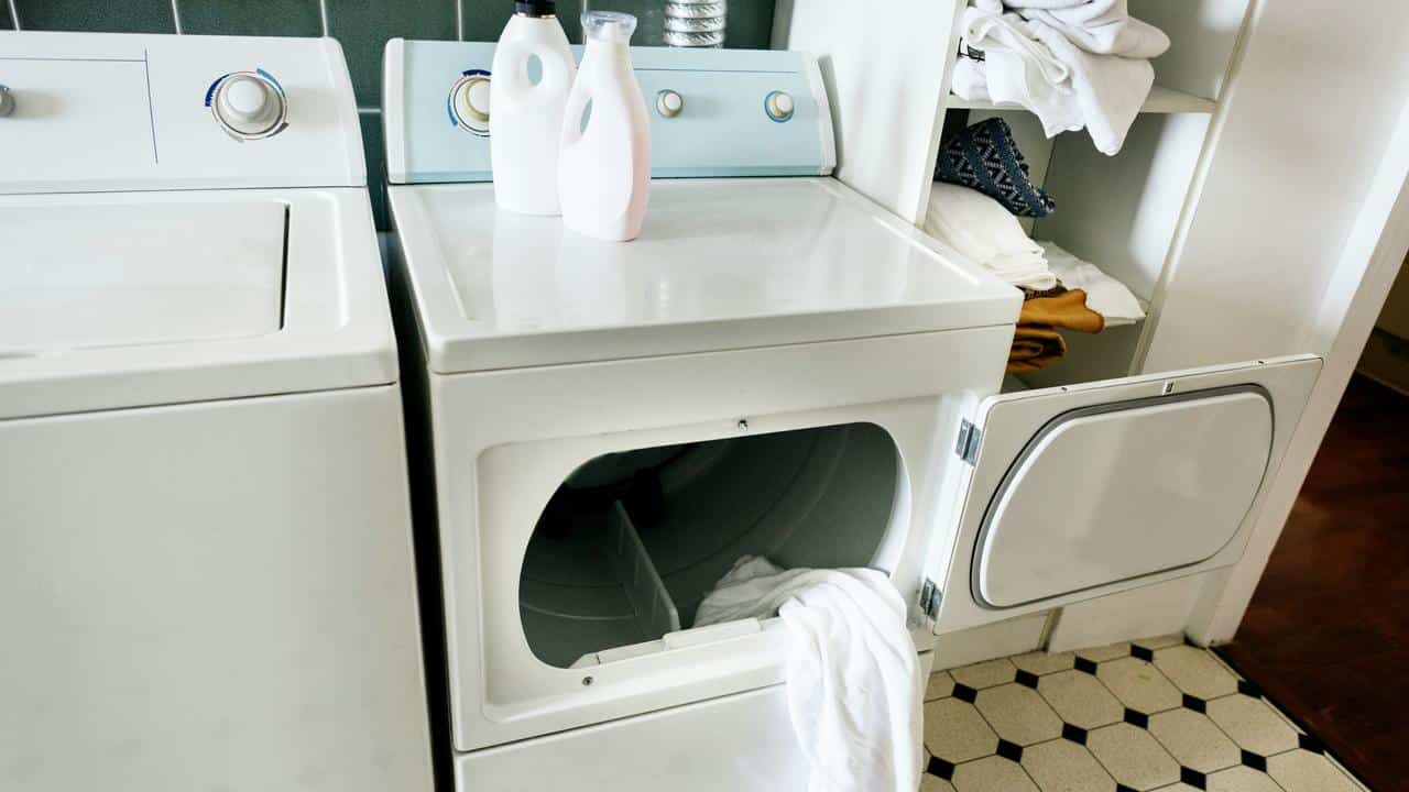 A laundry room with a washer, dryer, and cleaning supplies.