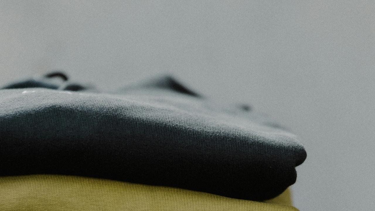 A stack of folded clothes on a surface.