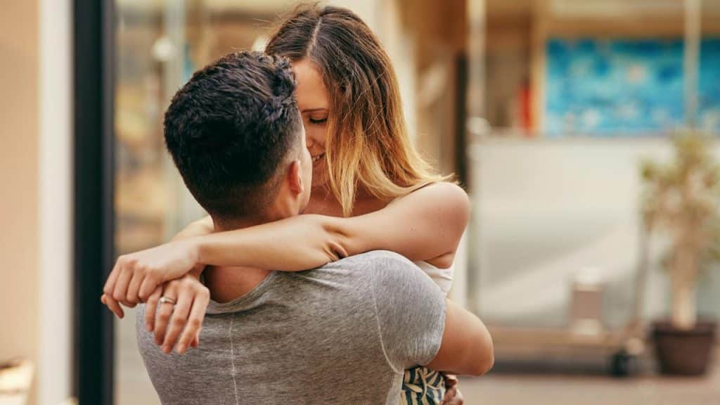 A couple embracing closely while smiling at each other.