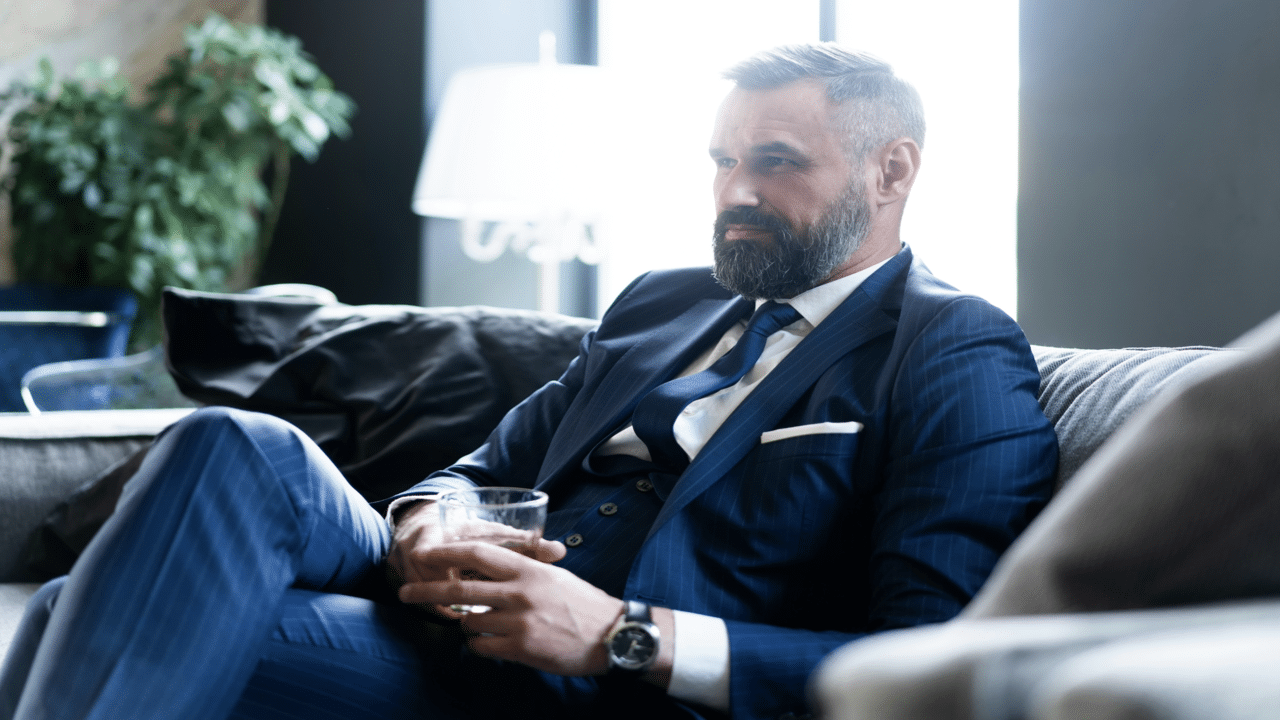 A handsome mature man drinking whiskey.