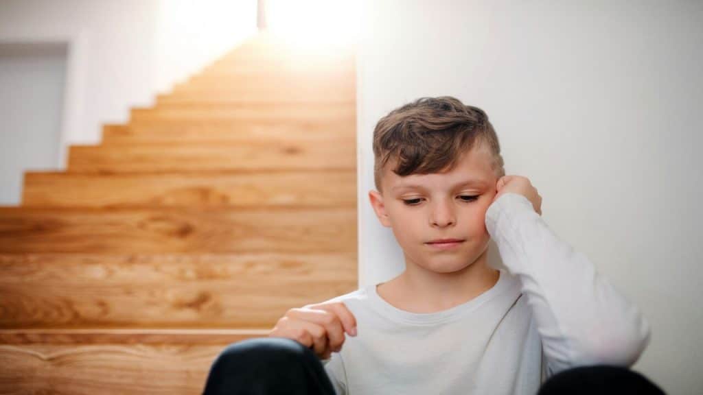 A kid looking sad at home