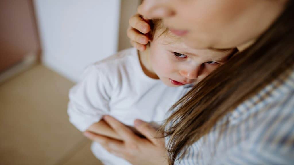 A child crying while her mom hugs her