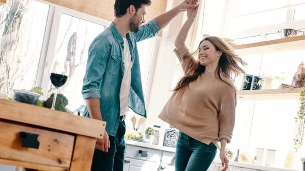 A couple dancing together in the kitchen