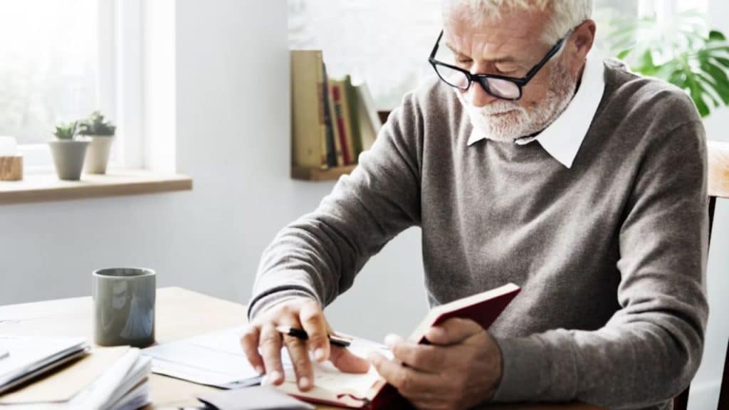 A man reviewing his bills at a kitchen table