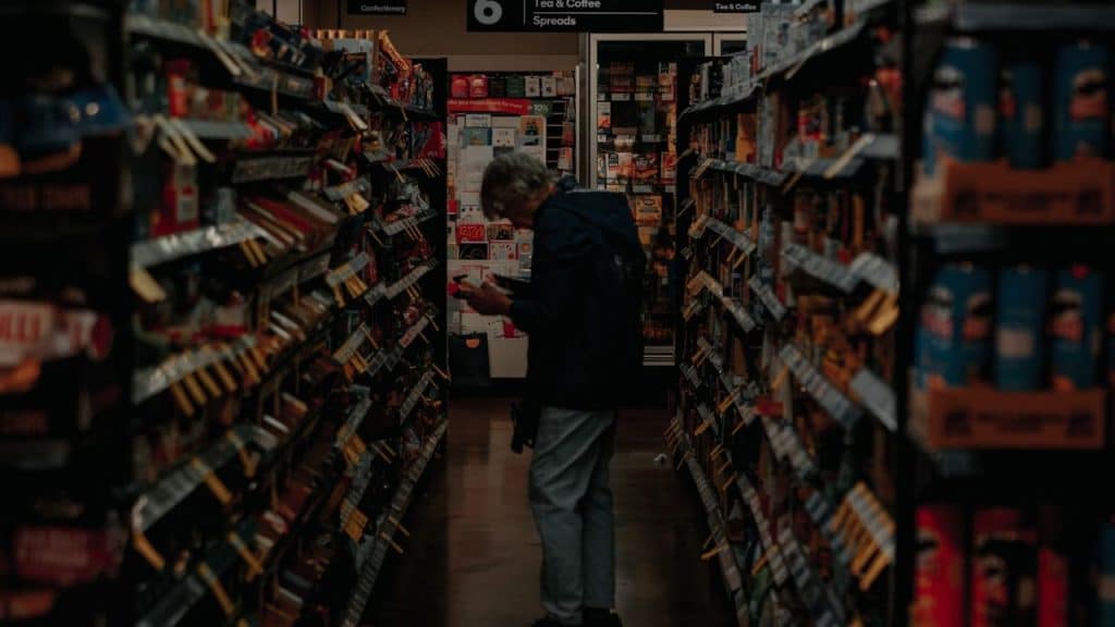 An elderly having a difficulty of picking the right food in the supermarket