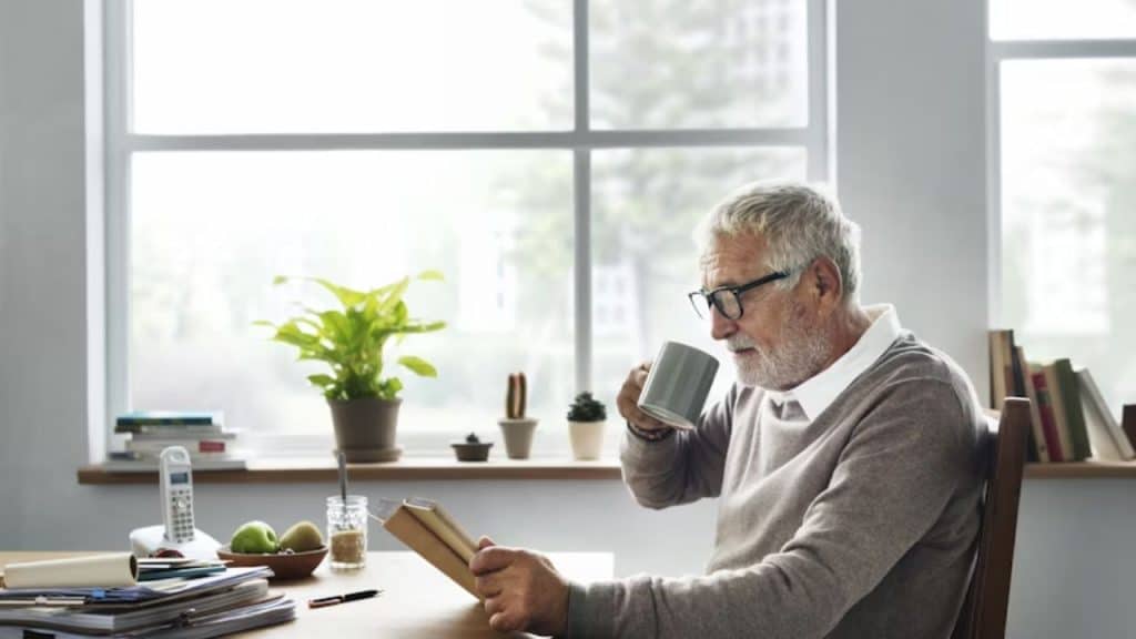 A man reading his ย journal at his desk