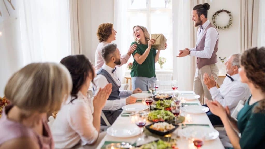 A man showing support while his partner speaks during a group dinner