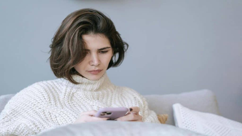 A woman looking sad while texting