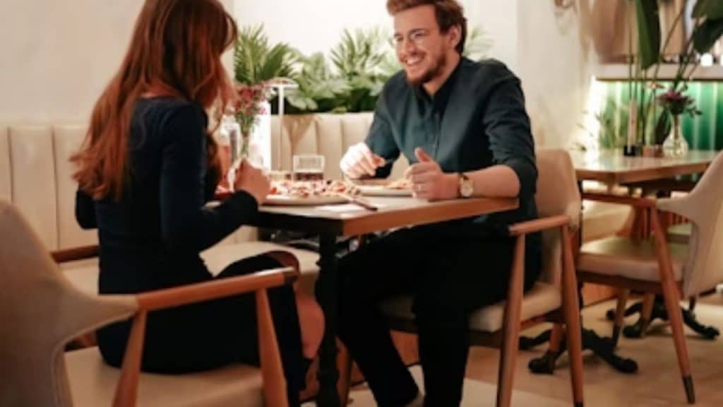 Man smiling while complimenting a woman across the table