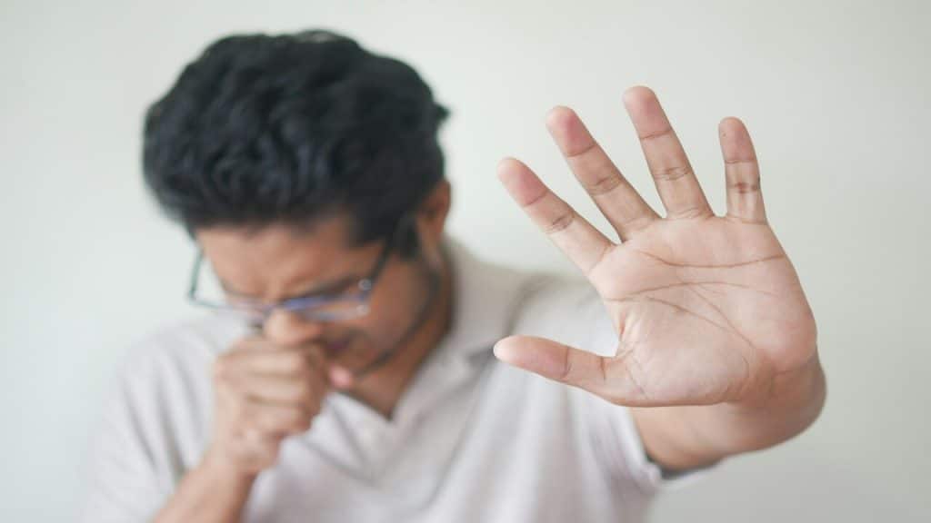 A man sneezing at home